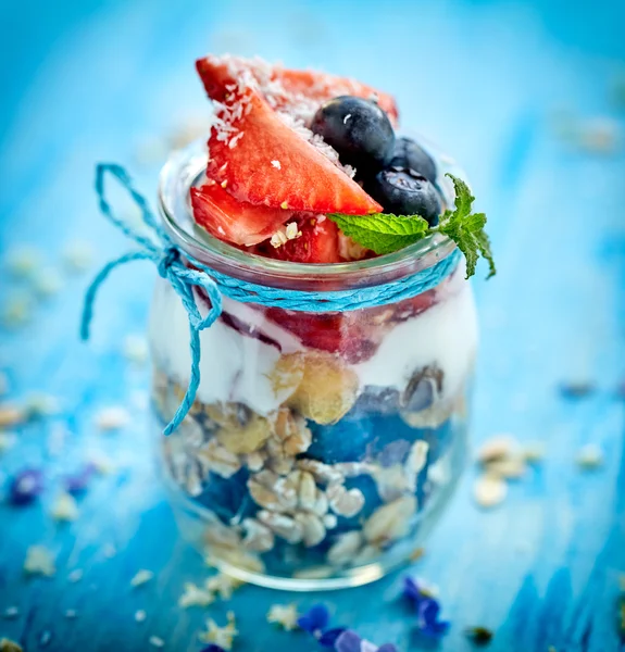 Morango blueberry iogurte parfait com adição de muesli, flocos de coco e hortelã fresca — Fotografia de Stock