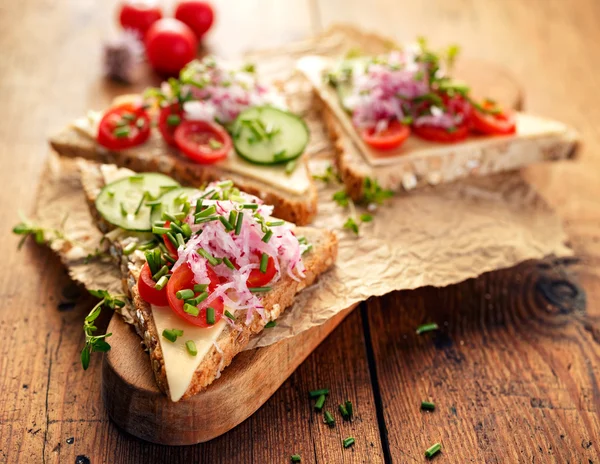 Sandwich with cheese, cherry tomatoes, cucumber, radish and fresh chives — Stock Photo, Image