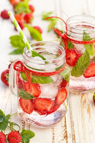 Agua con sabor a fresas frescas y menta en frascos de vidrio — Foto de Stock