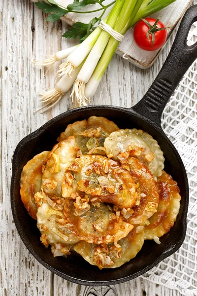 Baked dumplings on a cast-iron frying pan — Stock Photo, Image