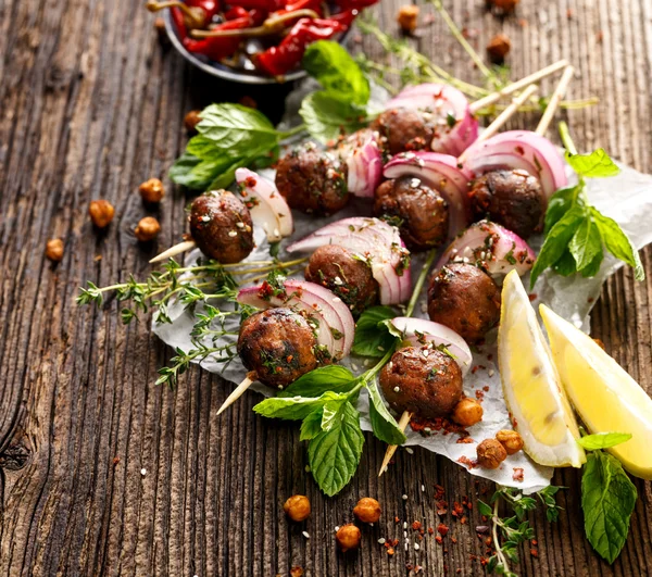 Kofta skewers, meatballs and red onion with addition of fresh mint and thyme — Stock Photo, Image