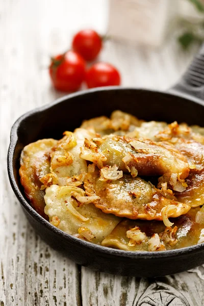 Baked dumplings on a cast-iron frying pan — Stock Photo, Image