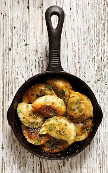 Baked dumplings on a cast-iron frying pan, top view — Stock Photo, Image