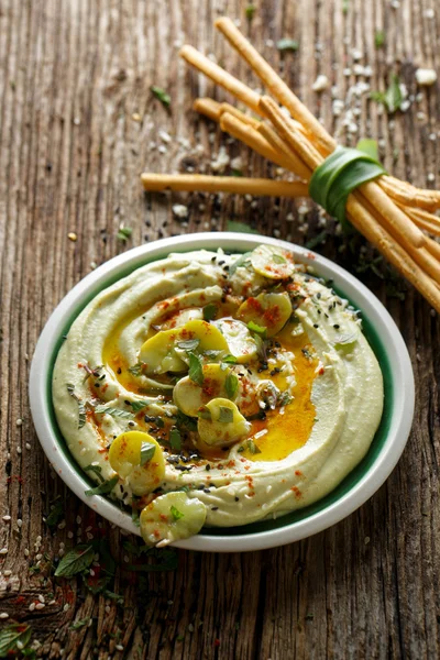 Hummus de feijão largo, com adição de azeite, páprica em pó, hortelã fresca e sementes de gergelim, delicioso e saudável mergulho vegan ou propagação — Fotografia de Stock