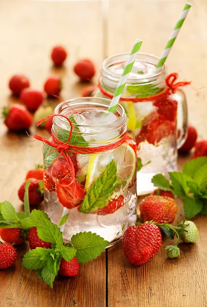 Agua fría refrescante con fresa fresca, limón y menta — Foto de Stock