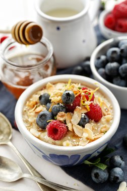 Ayrıca taze berry meyve, badem pul, susam tohumu, limon kabuğu ve ballı yulaf lapası. Lezzetli ve sağlıklı bir kahvaltı
