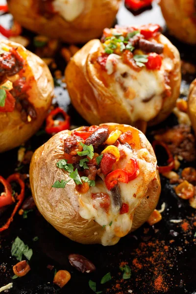 墨西哥风格的烤土豆 配上辣椒酱和奶酪 背景是黑色的 — 图库照片
