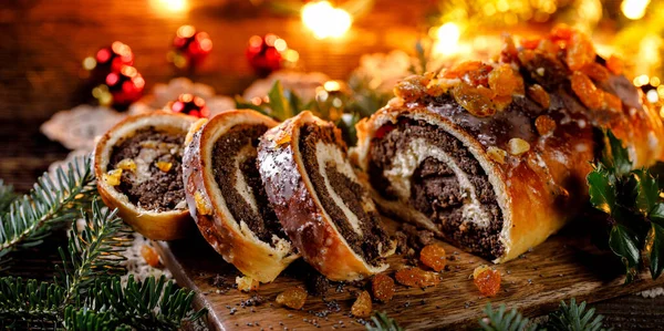 Christmas poppy seed cake, sliced poppy seed cake covered with icing and decorated with raisins on the holiday table. Traditional Christmas cake in Poland