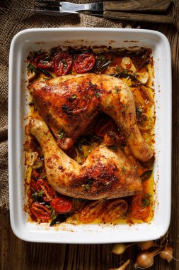 Fırında pişirilmiş tavuk budu, baharat ve otlarla servis edilir.