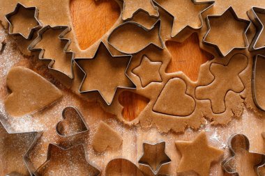 Noel kurabiyelerinin farklı şekillerini hamurdan keserek, manzarayı kapatarak.