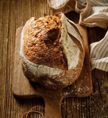 Ahşap bir tahtanın üzerinde geleneksel ekşi ekmek yakın görünüm