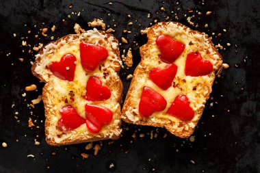 Siyah arka planda kırmızı biberli sıcak peynirli tost. Sevgililer Günü kahvaltısı ya da atıştırmalık bir şeyler.