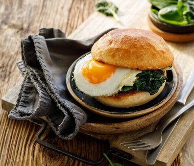 Tabakta servis edilen kızarmış yumurta ve ıspanakla vejetaryen burger.