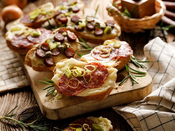 Bruschetta Mit Käse Salami Wurst Und Kräutern Auf Einem Brett — Stockfoto