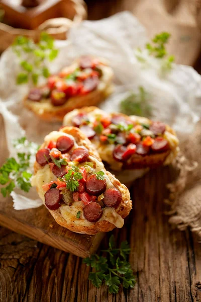 Bruschetta Con Formaggio Salsiccia Cosparsa Erbe Aromatiche Servite Una Tavola — Foto Stock