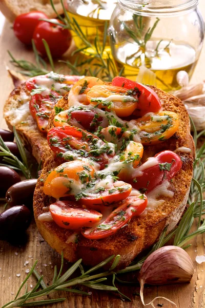 Bruschetta con tomates cherry, queso mozzarella y hierbas —  Fotos de Stock