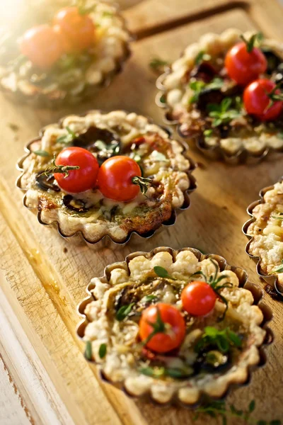 Tartas pequeñas con adición de tomate, calabacín, aceitunas y hierbas —  Fotos de Stock
