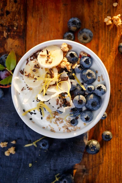 Yogur natural con adición de arándanos orgánicos, plátanos y muesli . — Foto de Stock