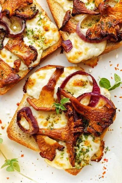 Bruschetta with chanterelle mushrooms, red onion, cheese and herbs — Stock Photo, Image