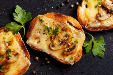 Crostini eritilmiş peynir, mantar ve taze maydanoz