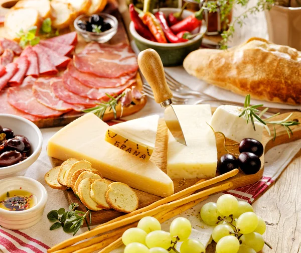 Various kinds of hard cheeses and cured meat — Stock Photo, Image