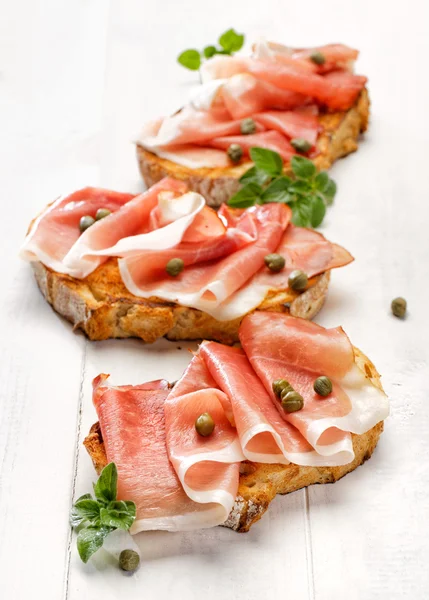 Sandwich con pan de campo a la parrilla con la adición de jamón ahumado y alcaparras — Foto de Stock