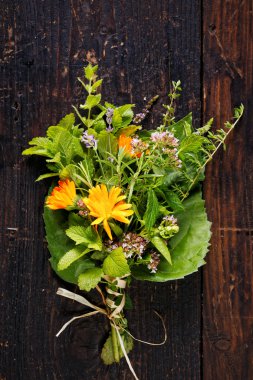Ahşap arka plan üzerinde çeşitli taze organik otlar buketi