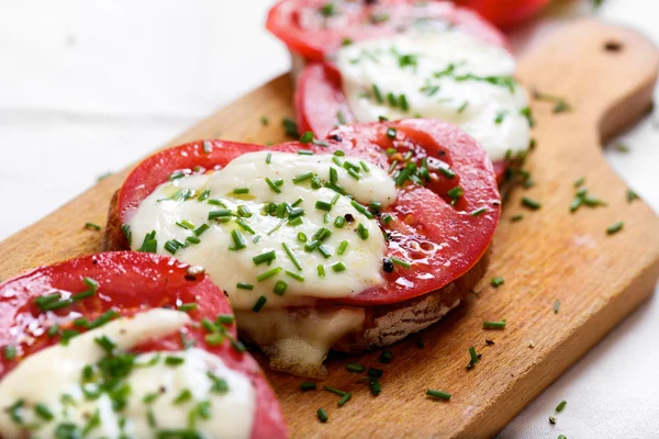 Bruschetta with tomato, mozzarella cheese and fresh chive — Stock Photo, Image