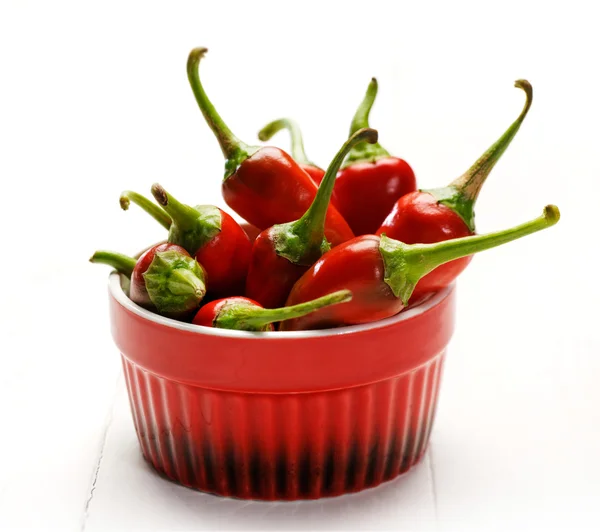 Färska chilipeppar i en röd skål — Stockfoto