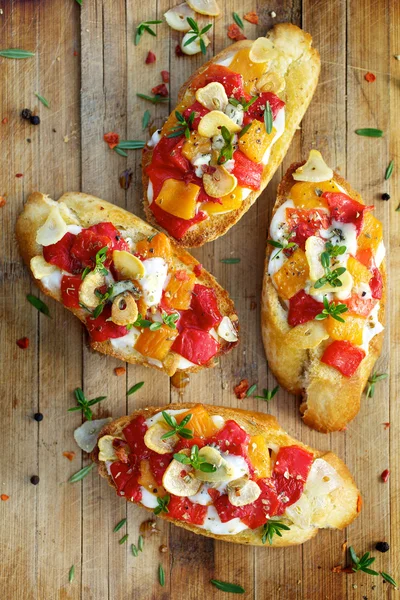 Bruschetta con pimiento asado, queso de cabra, ajo y hierbas — Foto de Stock