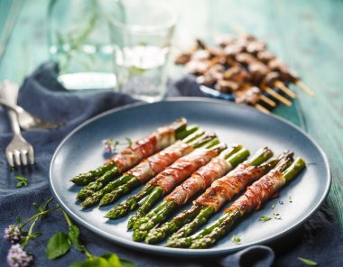 Grilled green asparagus wrapped with bacon clipart