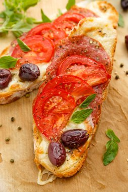 Bruschetta mozzarella peyniri, salam, domates ve kalamata zeytin ile