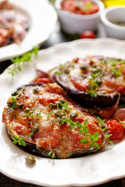 Grilled eggplant stuffed with tomatoes and cheese with capers and herbs — Stock Photo, Image