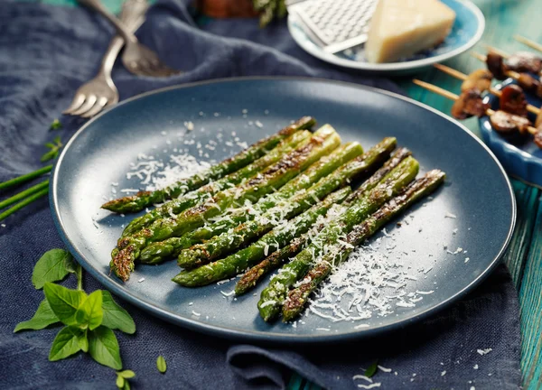 Gegrilde groene asperges met toevoeging van Parmezaanse kaas op een plaat — Stockfoto