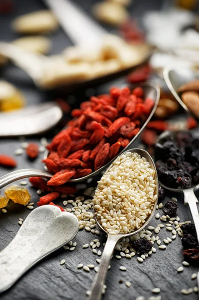 Sementes de sésamo, bagas de goji e passas — Fotografia de Stock