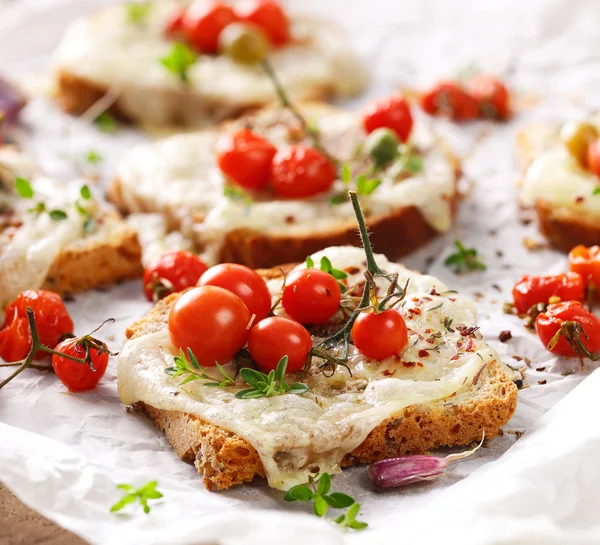 Bruschetta met kaas, cherry tomaten en kruiden — Stockfoto