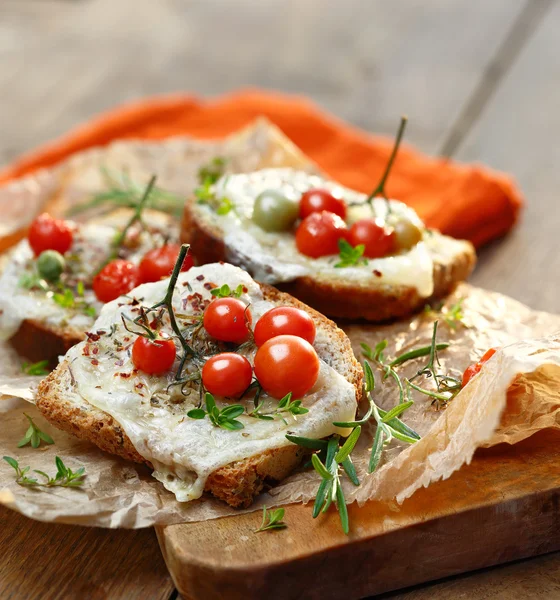 Bruschetta con queso, tomates cherry y hierbas aromáticas —  Fotos de Stock