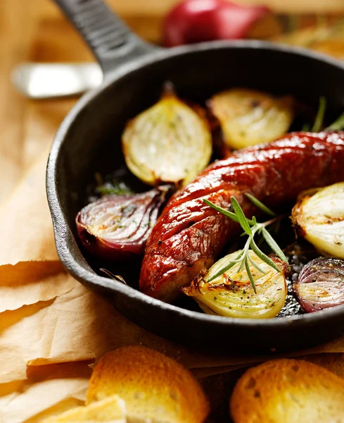 Roast sausage with onions and rosemary — Stock Photo, Image