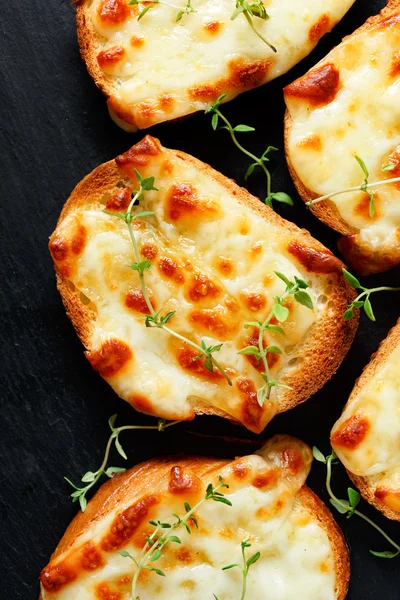Crostini with melted cheese  and fresh thyme — Stock Photo, Image