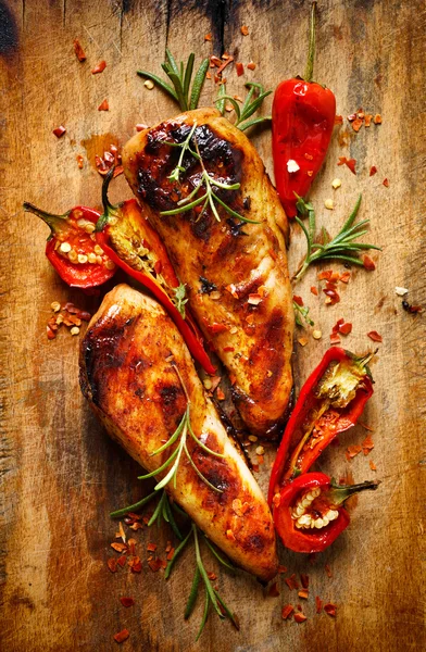 Grilované filety kuřecí v pikantní marinádě s přídavkem chilli na dřevěné pozadí — Stock fotografie