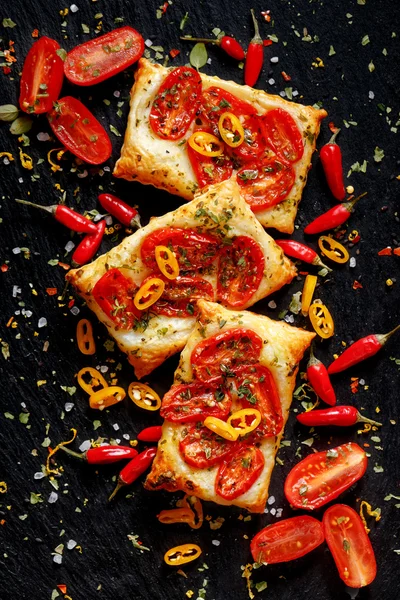 Puff pastry with tomatoes, chili peppers and herbs. — Stock Photo, Image