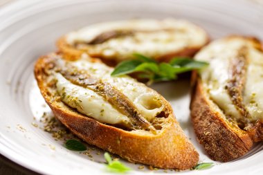 Balık, mozzarella peyniri ve kekik beyaz tabakta crostini
