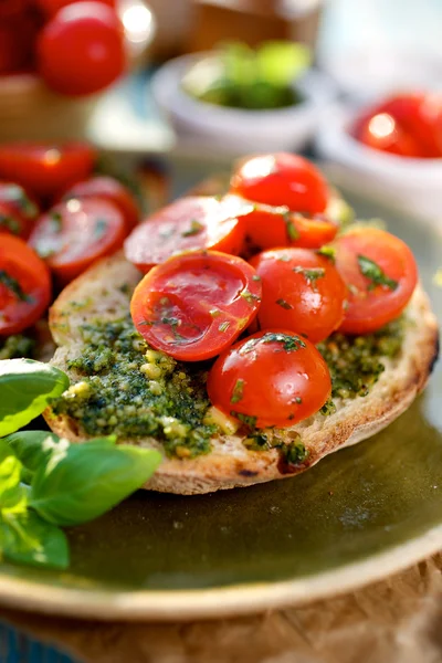 Bruschetta con tomates cherry frescos y pesto aromático de hierbas —  Fotos de Stock