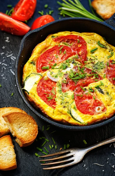 Frittata with tomatoes and fresh chives on a pan — Stock Photo, Image