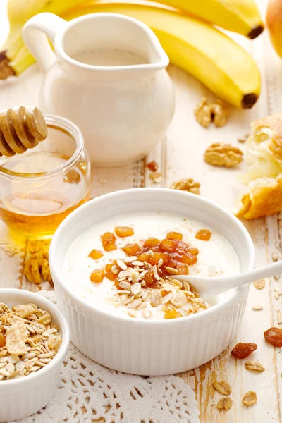 Micul dejun sănătos, iaurt natural cu mere coapte și muesli pe masă albă din lemn — Fotografie, imagine de stoc
