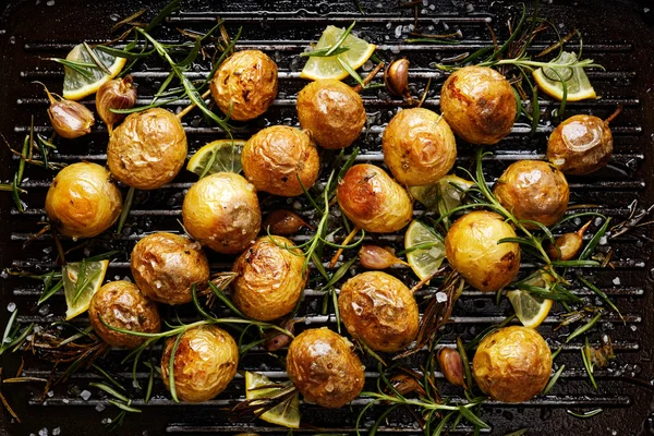 Biberiye, sarımsak, limon ve deniz ile kavrulmuş patates bir ızgara tava tuz