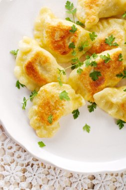 Beyaz tabakta kızarmış hamur köftesi.