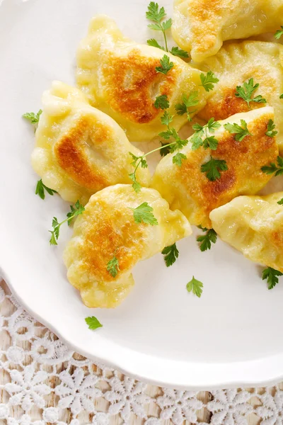 Beyaz tabakta kızarmış hamur köftesi.