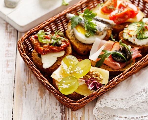 Canapes with various toppings, delicious breakfast or snack — Stock Photo, Image