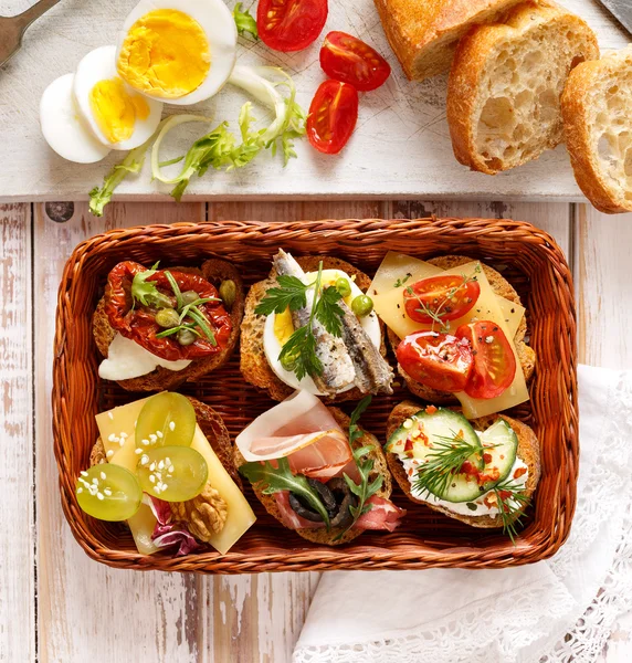Kanapéer med olika pålägg, läcker frukost eller mellanmål — Stockfoto